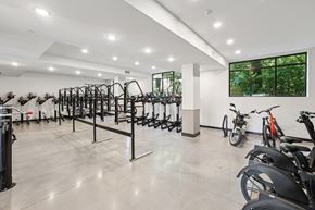 Charlotte apartment for rent - A gym with a row of exercise bikes and a row of treadmills at Link Apartments® CYKEL Apartments, Charlotte, NC