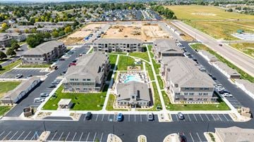 Evans apartment for rent - A large, modern housing complex with a parking lot in the foreground.