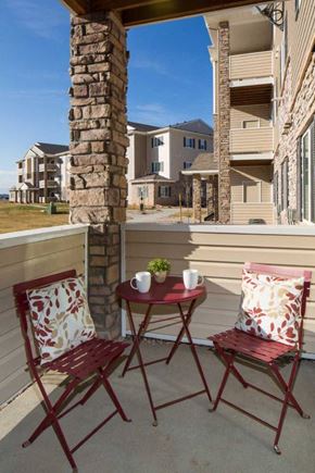 Loveland apartment for rent - a patio with two chairs and a table on a balcony