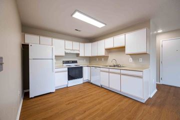 Evans apartment for rent - A kitchen with white cabinets and a wooden floor.