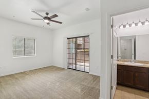 North Las Vegas apartment for rent - A spacious room with a ceiling fan and a sliding glass door leading to a backyard. at Rome Park Villas, Nevada