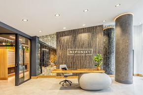 Quincy apartment for rent - A modern office space with a wooden reception desk and a large stone pillar.