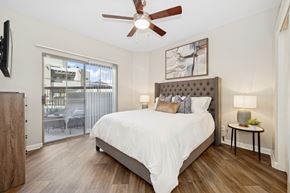 Scottsdale apartment for rent - A bedroom with a bed, a ceiling fan, and a sliding glass door.