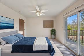 Reno apartment for rent - A bedroom with a bed, a ceiling fan, and a painting on the wall.