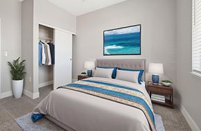 Henderson apartment for rent - A bedroom with a large bed and a painting of a beach scene on the wall.