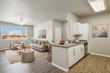 Sacramento apartment for rent - A well-lit, spacious living room with a kitchen area in the background.