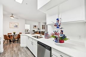 Aurora apartment for rent - A kitchen with white cabinets and a wooden floor.