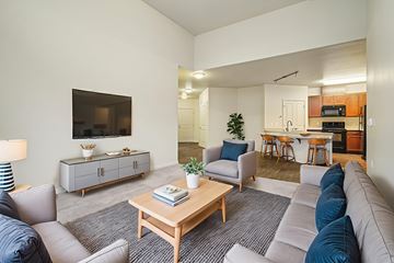 Redmond apartment for rent - A living room with a grey couch, a wooden coffee table, and a television on the wall.