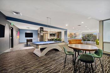 Resident social lounge with demonstration kitchen and billiards table, shuffleboard table and arcade games