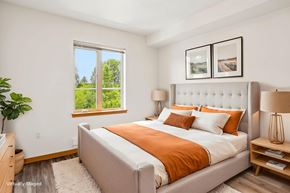 Lynnwood apartment for rent - A bedroom with a large bed and a window overlooking a green landscape.