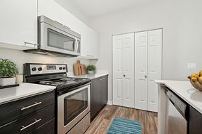 Hillsboro apartment for rent - A modern kitchen with a black stove top oven and a silver microwave above it.