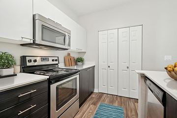 Hillsboro apartment for rent - A modern kitchen with a black stove top oven and a silver microwave above it.