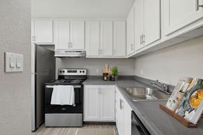 Sparks apartment for rent - a white kitchen with stainless steel appliances and white cabinets