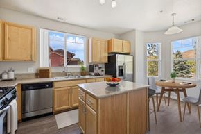 Sparks apartment for rent - a kitchen with wooden cabinets and a table with a bowl of fruit