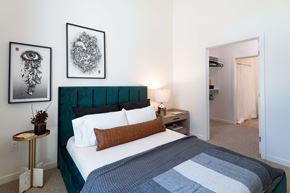Sacramento apartment for rent - A bedroom with a bed, nightstand, and two pictures on the wall.