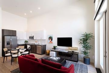 Sacramento apartment for rent - A modern living room with a red couch and a television.