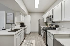 Sparks apartment for rent - a spacious kitchen with white cabinets and stainless steel appliances