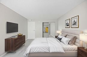 Reno apartment for rent - A bedroom with a large bed and a TV on the wall.