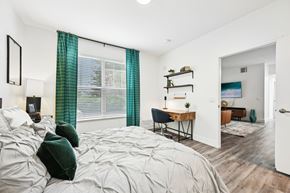 Aurora apartment for rent - A bedroom with a large bed and a desk with a chair.