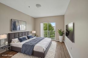 Portland apartment for rent - A bedroom with a large bed and a flat screen TV mounted on the wall.