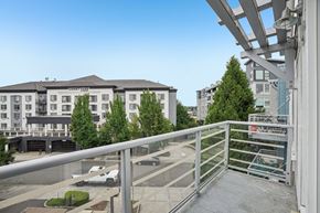 Portland apartment for rent - A view of a courtyard with a building in the background and a white van parked in the foreground.