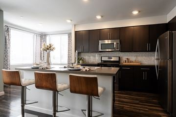 San Diego apartment for rent - A modern kitchen with dark brown cabinets and a white island.
