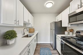 Denver apartment for rent - A kitchen with white cabinets and a black refrigerator.