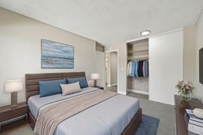 Denver apartment for rent - A bedroom with a large bed and a painting on the wall.