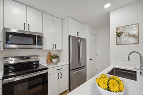 Beaverton apartment for rent - A modern kitchen with white cabinets and stainless steel appliances.