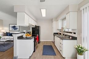 Henderson apartment for rent - A modern kitchen with white cabinets and a black countertop.