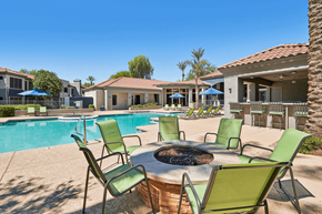 Phoenix apartment for rent - A poolside area with a fire pit and chairs.