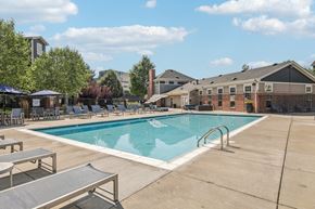 Denver apartment for rent - A swimming pool surrounded by lounge chairs and umbrellas.