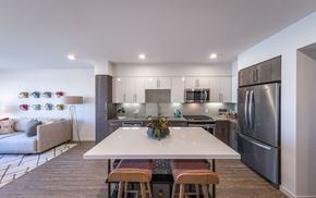 Milpitas apartment for rent - a kitchen with stainless steel appliances and a white island with four chairs