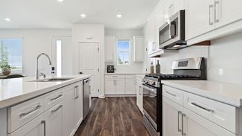 Stainless steel appliances including built-in microwave, refrigerator, dishwasher, and gas range