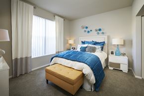 Denver apartment for rent - a bedroom with a large bed and blue and white bedding