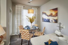 Denver apartment for rent - a dining room with a table and chairs and a painting on the wall