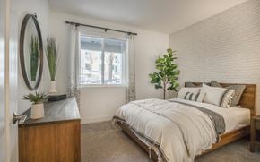 Anaheim apartment for rent - a bedroom with a bed and a dresser and a window