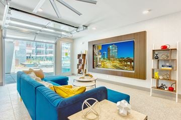 Phoenix apartment for rent - A living room with a blue couch and a television on the wall.