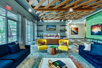 Resident social lounge and game room with demonstration kitchen, billiards table, shuffleboard table, and arcade games