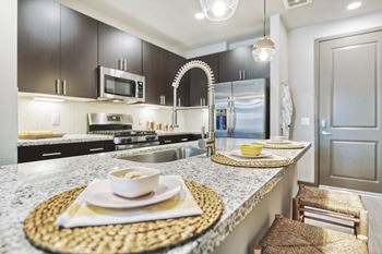Stainless steel appliances including built-in microwave, refrigerator, gas range, and dishwasher