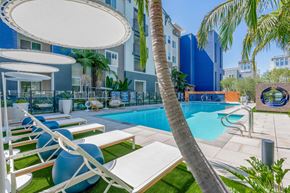 Anaheim apartment for rent - A pool area with lounge chairs and umbrellas.