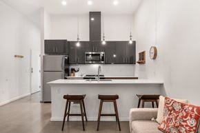 Seattle apartment for rent - A modern kitchen with a bar stool and a couch.