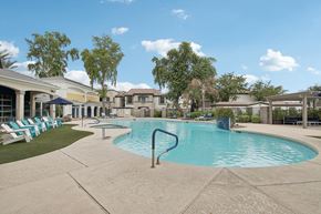 Chandler apartment for rent - a swimming pool with chairs and a building in the background