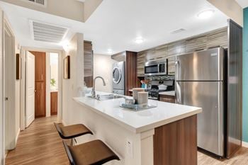 Stainless steel appliances including built-in microwave, gas range, refrigerator, and dishwasher