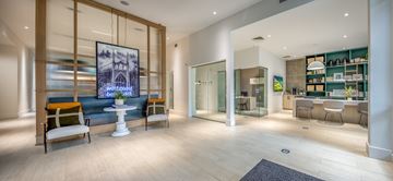 Portland apartment for rent - A modern living room with a large painting on the wall and a kitchen area in the background.
