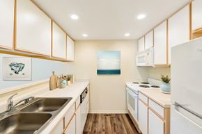 Reno apartment for rent - a kitchen with white appliances and wooden cabinets and a sink