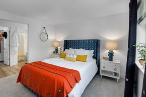 Kent apartment for rent - A bedroom with a white bed and orange bedspread.