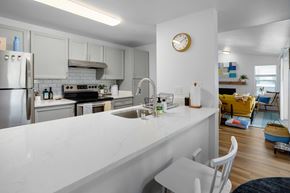 Kent apartment for rent - A kitchen with a white counter top and a clock on the wall.