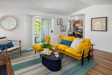 Kent apartment for rent - A living room with a yellow couch and a blue coffee table.