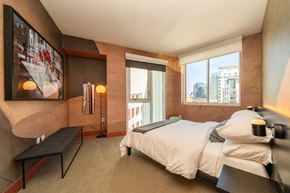 San Diego apartment for rent - A bedroom with a large bed and a view of the city.